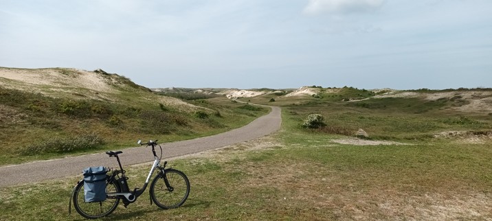 Duinen und  Fietspad soweit die Augen reichen, im Vordergrund ein Fahrrad/Pedelec, im Hintergrund ein Fietspad links und rechts Duinen! Noordholland Duinreservaat!